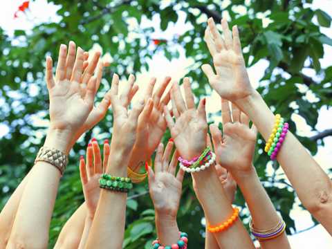 hands up in the air with friendship bracelets on wrists