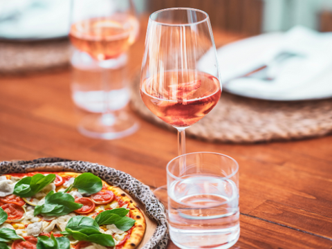Pissa on a table with glasses of rosé wine