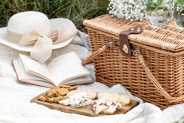 picnic basket with blanket, cheeses and book