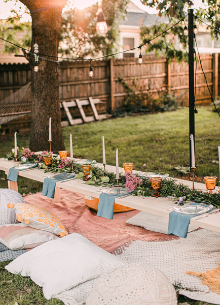 outdoor picnic with cushions candles and flowers