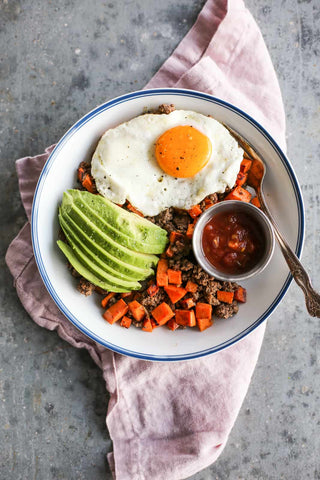 Bison breakfast hash recipe with sweet potato, fried egg, avocado, and ground bison.