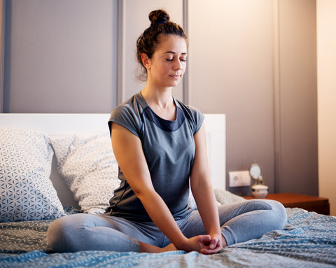 woman meditating in bed