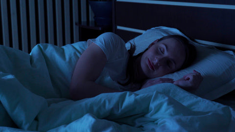 A woman sleeping in a dark room.