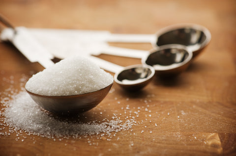 Sugar in a measuring spoon.