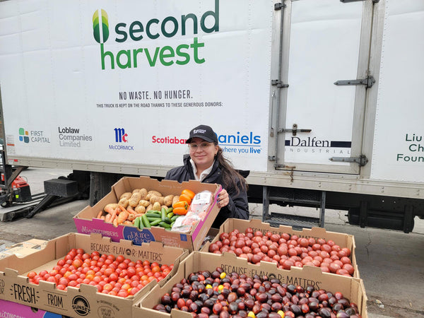 Second Harvest employee with boxes of vegetables