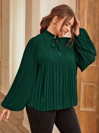 a woman wearing a green pleated blouse