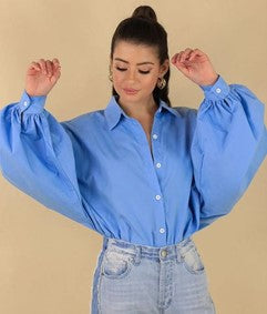 a woman wearing a blue blouse with jeans