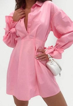 a woman wearing a long pink blouse