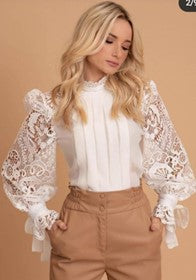a woman wearing a white blouse with lace