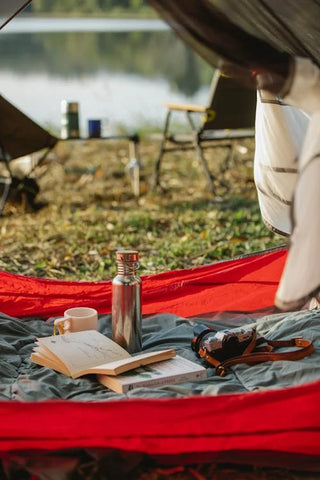 camp tent with a book a camera and chairs