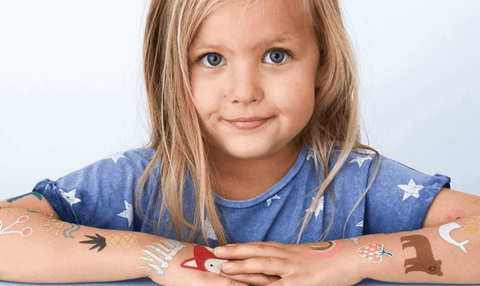 little girl with temporary tattoos on her arms