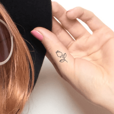 tiny rose tattoo on thumb