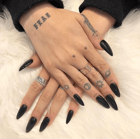 tiny tattoos on fingers with black nails