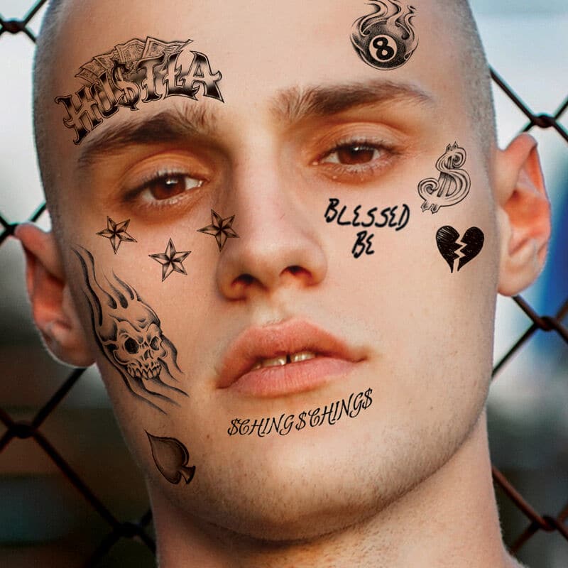 Blessed lettering tattoo on Travis Barkers face