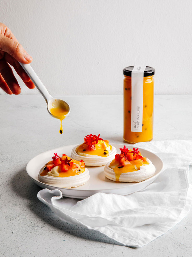 Mini pavlovas drizzled in passionfruit and mango jam.