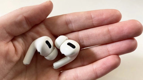 A Hand Holding a Pair of Wireless Earbuds