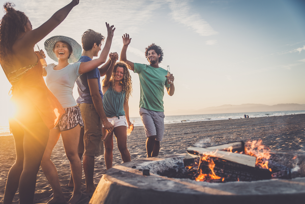 young people enjoying a bonfire on the beach