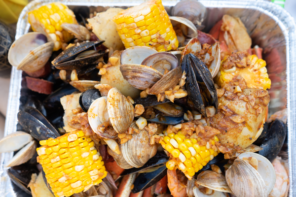 A traditional New England clambake with corn, mussels, and potatoes