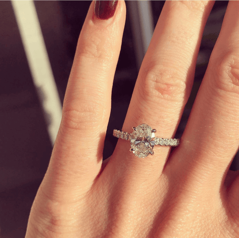 Left hand featuring diamond halo engagement ring