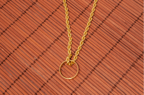 yellow gold ring worn on yellow gold chain