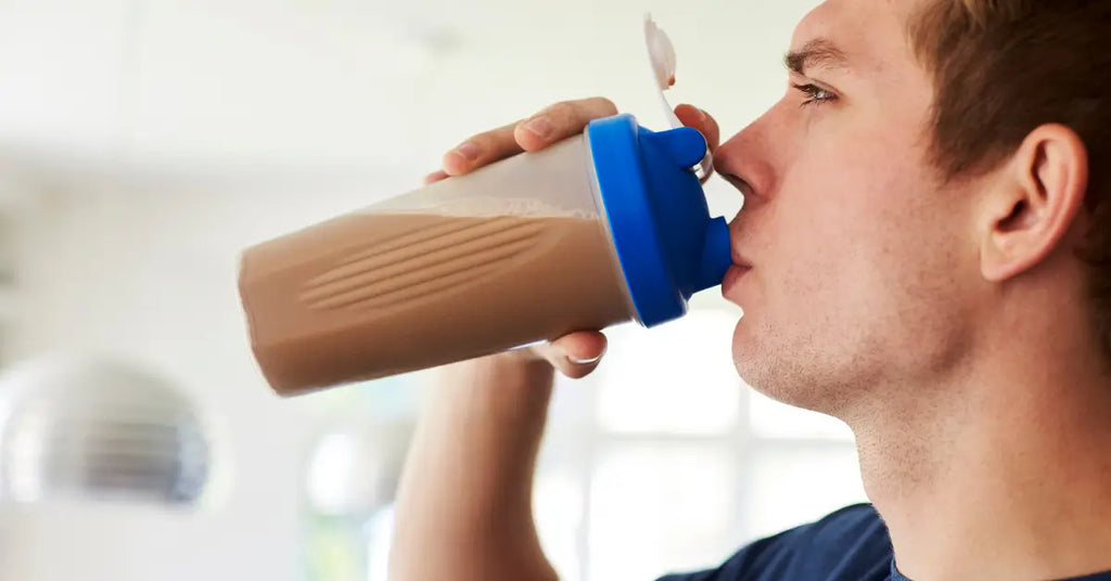 Man drinking from a protein shaker, questioning if protein powder can be consumed without exercising