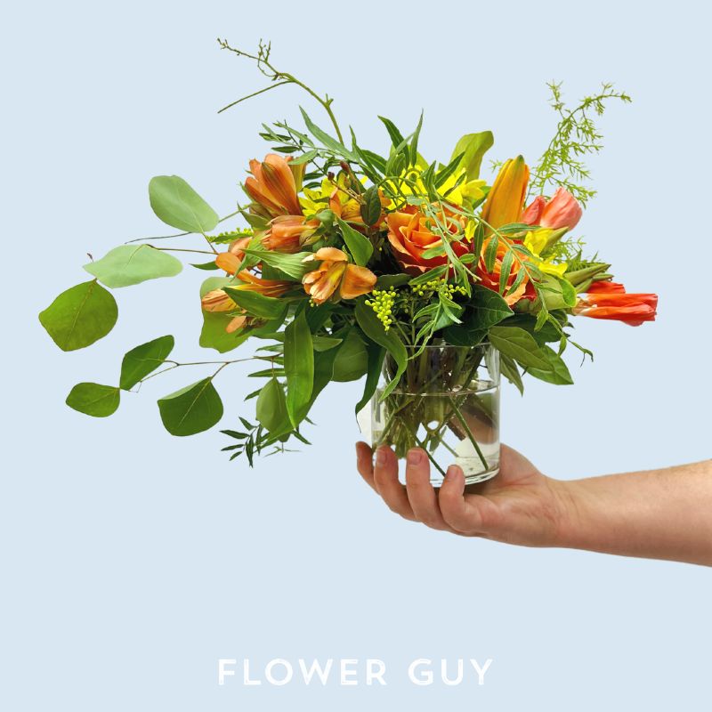 Mr Brightside flower arrangement with orange seasonal flowers in a glass vase from Flower Guy
