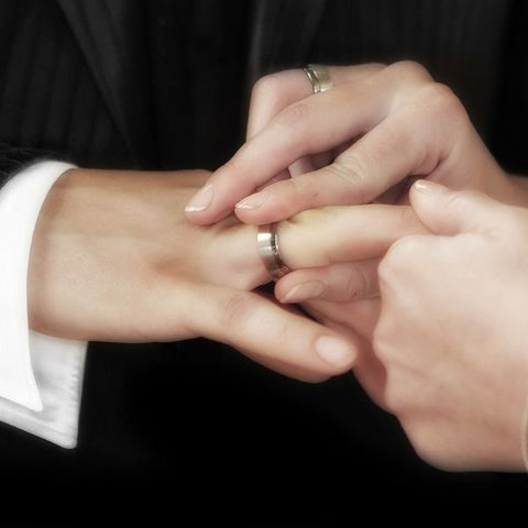 Frau trägt Ehering am Finger des Mannes