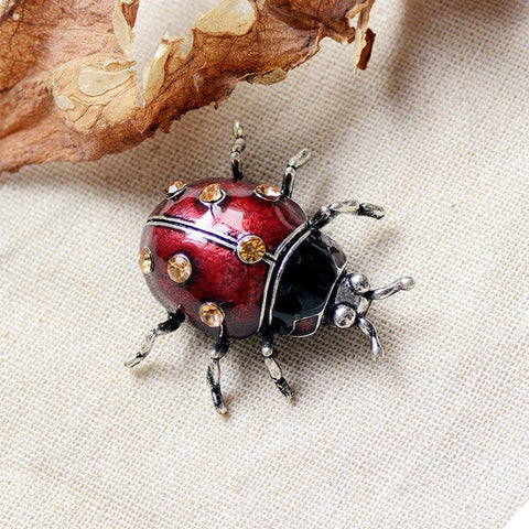 glaze ladybug brooch infront of branch