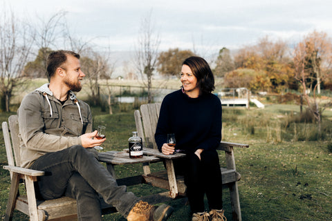 Two people sitting outside enjoying a Backwoods whisky together
