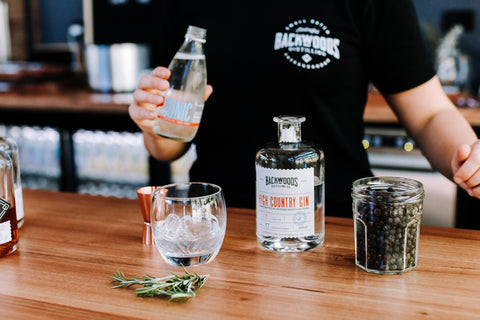 Woman in black tshirt making a gin and tonic with High Country Gin