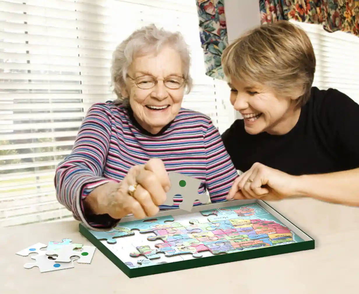 Elderly women doing cartoon states jigsaw puzzle smiling