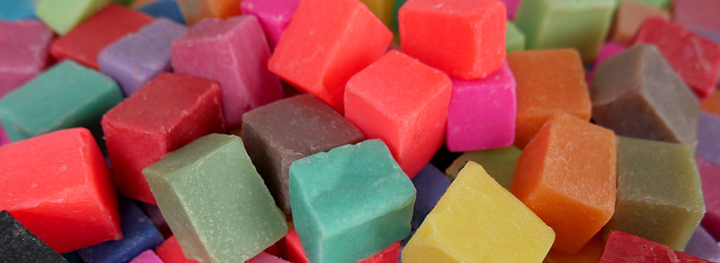 Multicolored soap dough cubes covering surface.