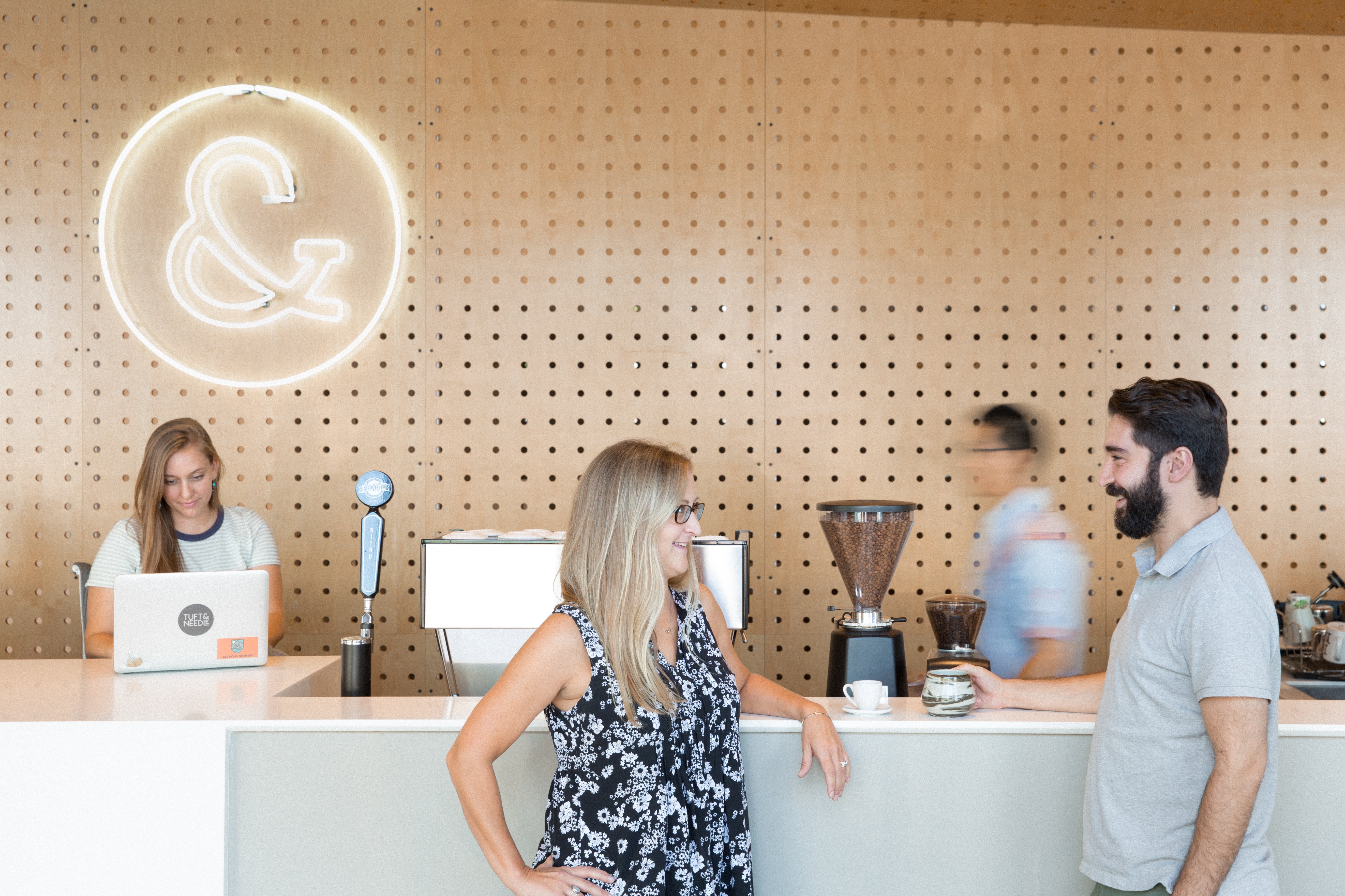 Picture of Tuft & Needle Employees standing around the coffee machine talking