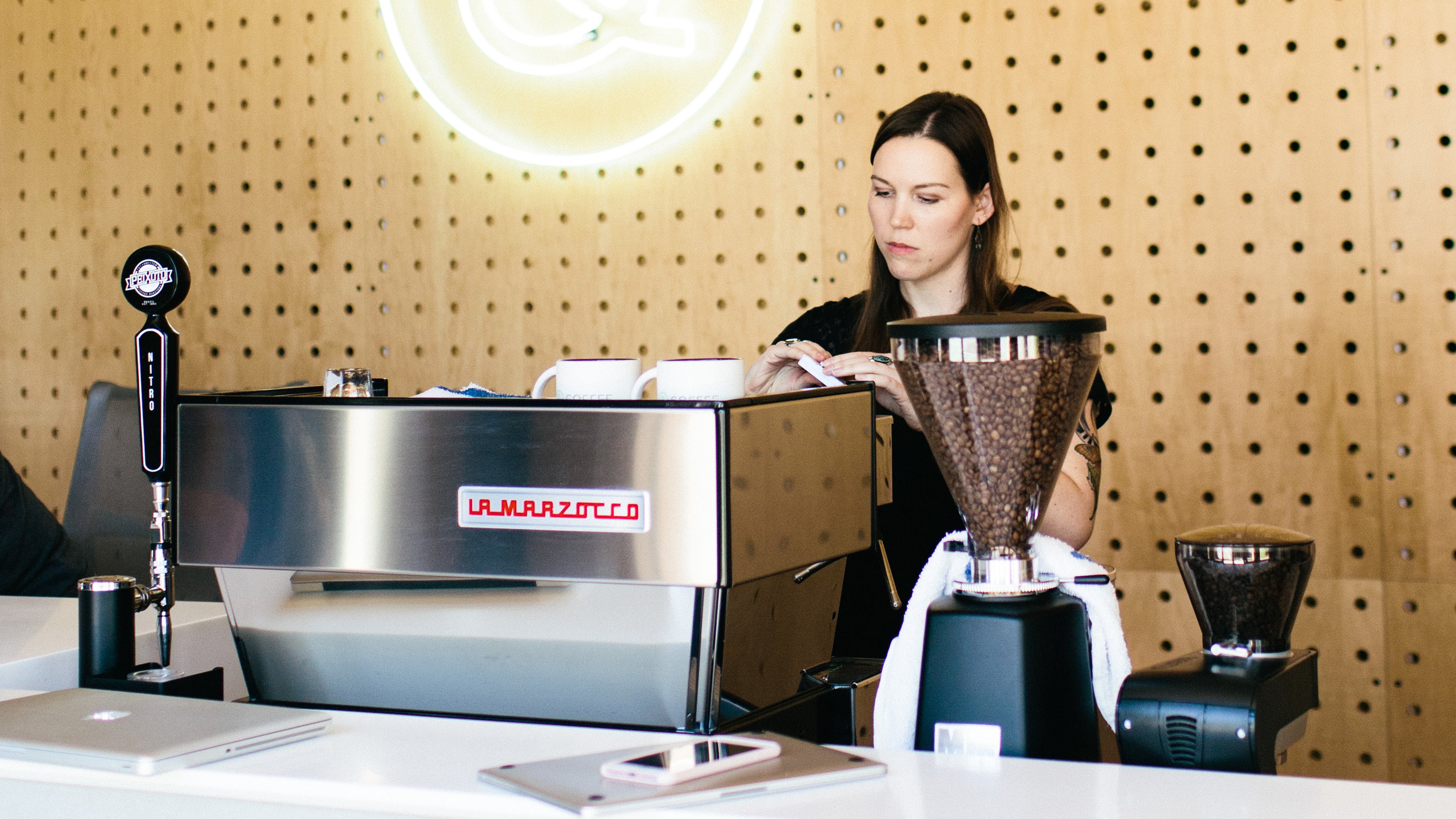 Picture of a Tuft & Needle Employee making coffee at the coffe bar in the Phoenix office