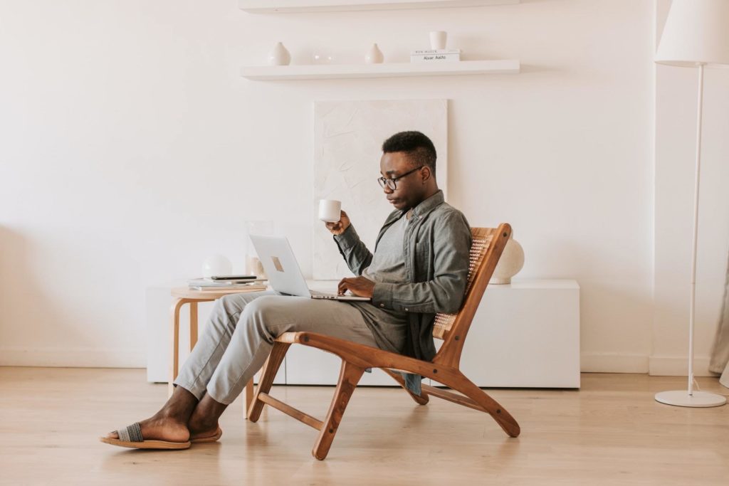 Man drinking coffee while on the computer.