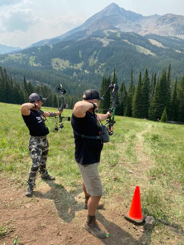 Two archers aim downrange at a Total Archery Challenge in Big Sky, Montana