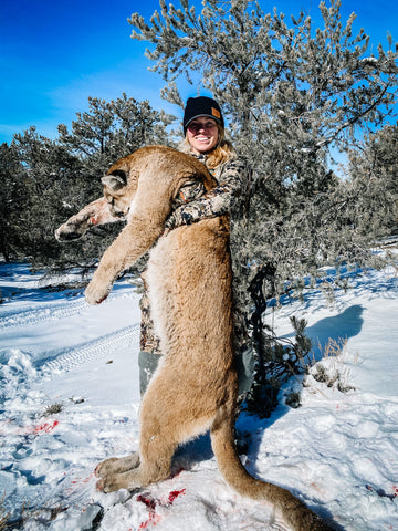 Female Hunter holding a mountain lion in SITKA Gear