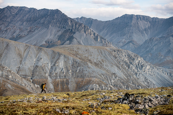 A man hiking against a backdrop of mountains