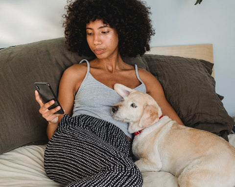 woman lounging with mid-sized white dog