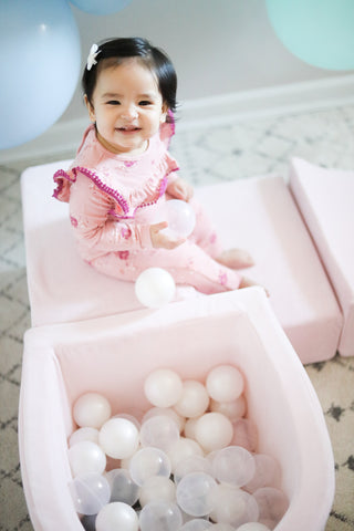 smiling girl sitting on luxury pink ball pit by meowbaby