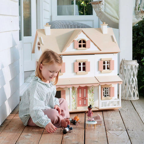 girl kneeling in front of tender leaf hummingbird dolls house