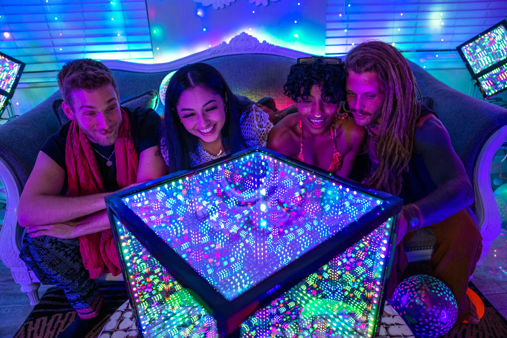 A group of people sitting on a couch in front of a glowing cube decorated with the best Christmas lights.