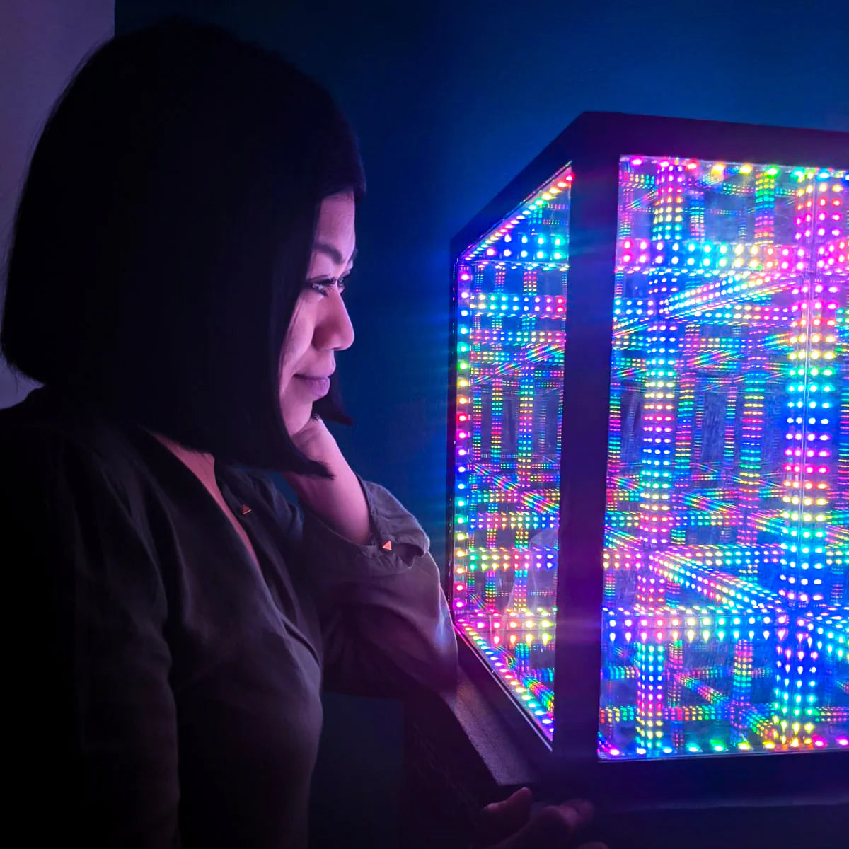 A woman fascinated by a stunning LED cube adorned with the best Christmas lights.