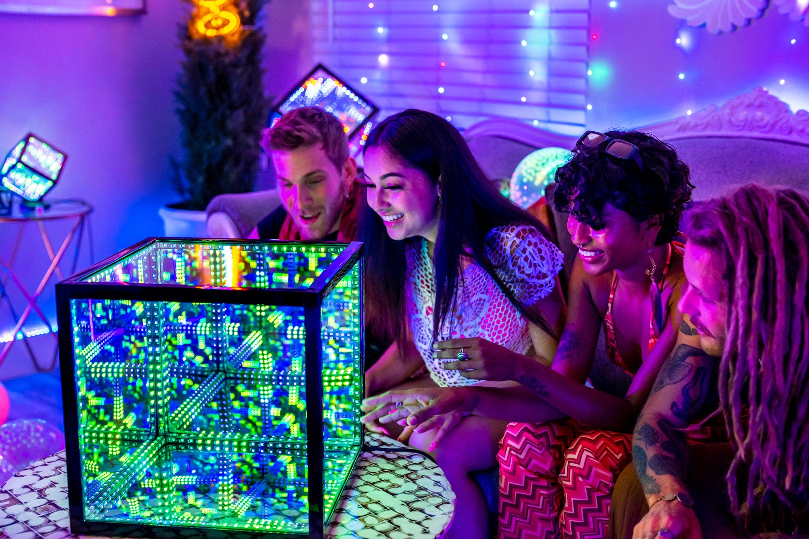 Friends on couch in bedroom looking at HyperCube that is part of host’s bedroom mood lighting ideas