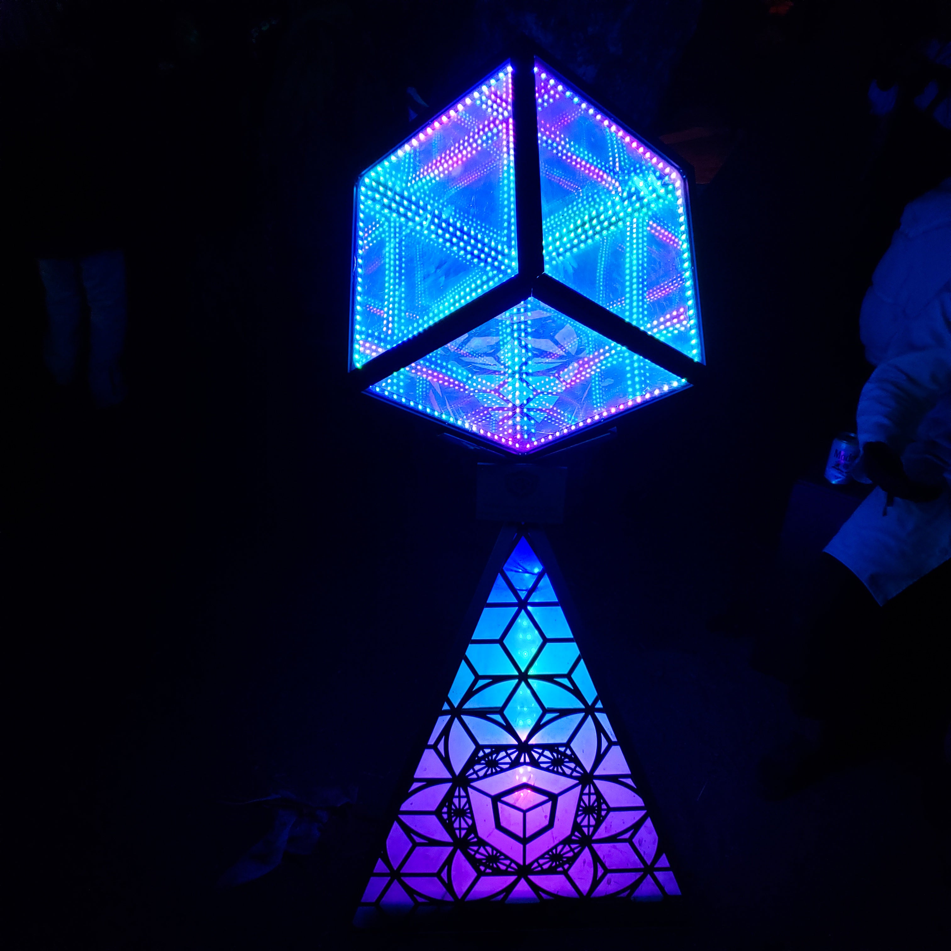 HyperCube on top of a triangle of light in a man cave after a man read about the features to include in a man when reading an article about, “what is a man cave”