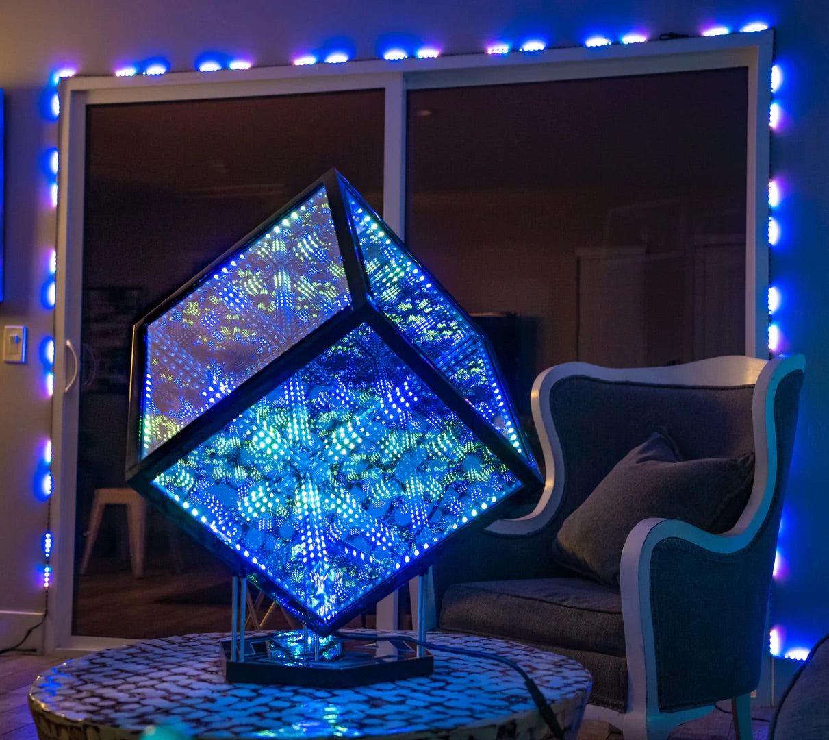 HyperCube on coffee table as a statement decorative lighting piece for living room, next to couch and entryway lined with LED lights