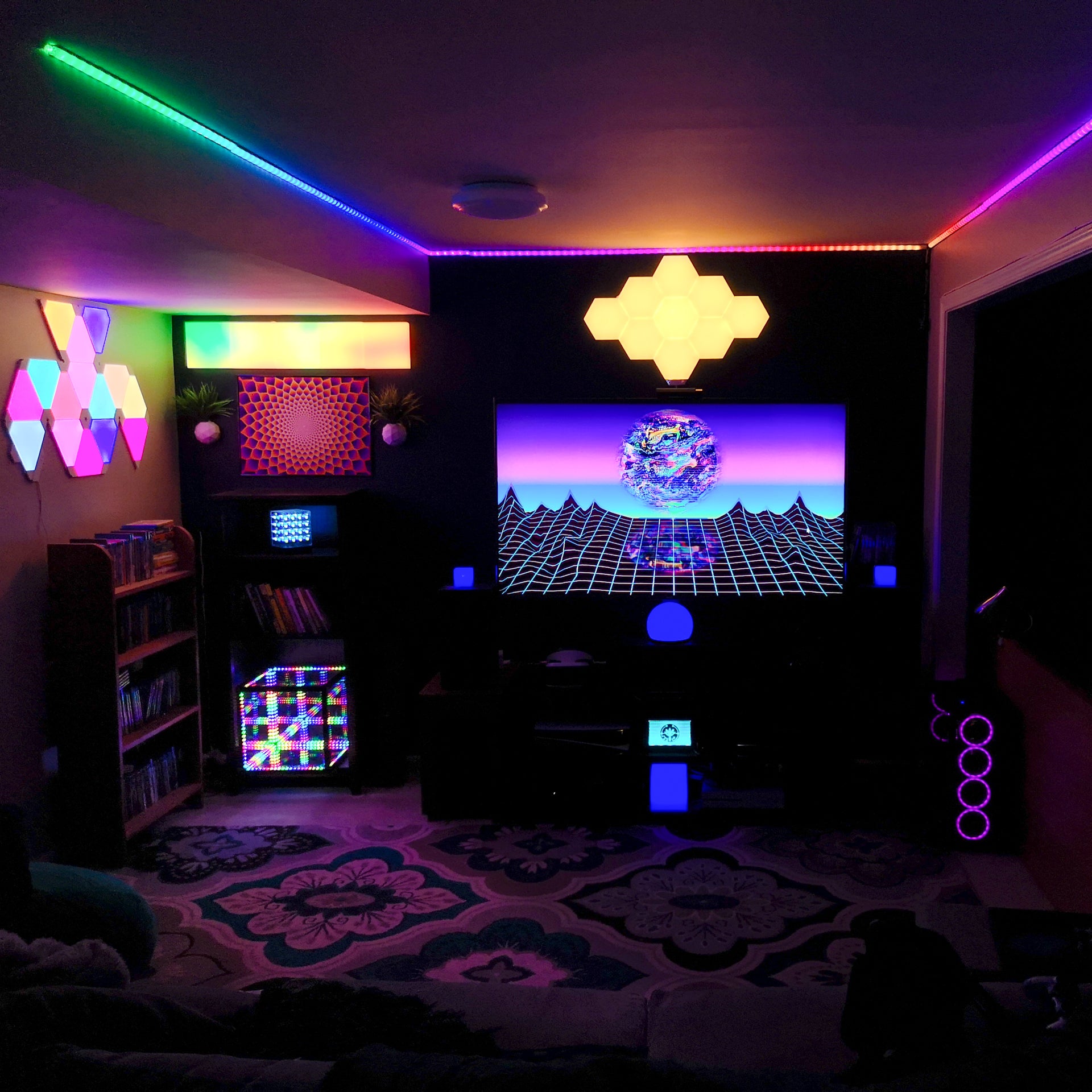 Man cave with a TV in the center of the room, LED lights around the cieling, and HyperCubes to the left of the room for enhanced visual relaxation