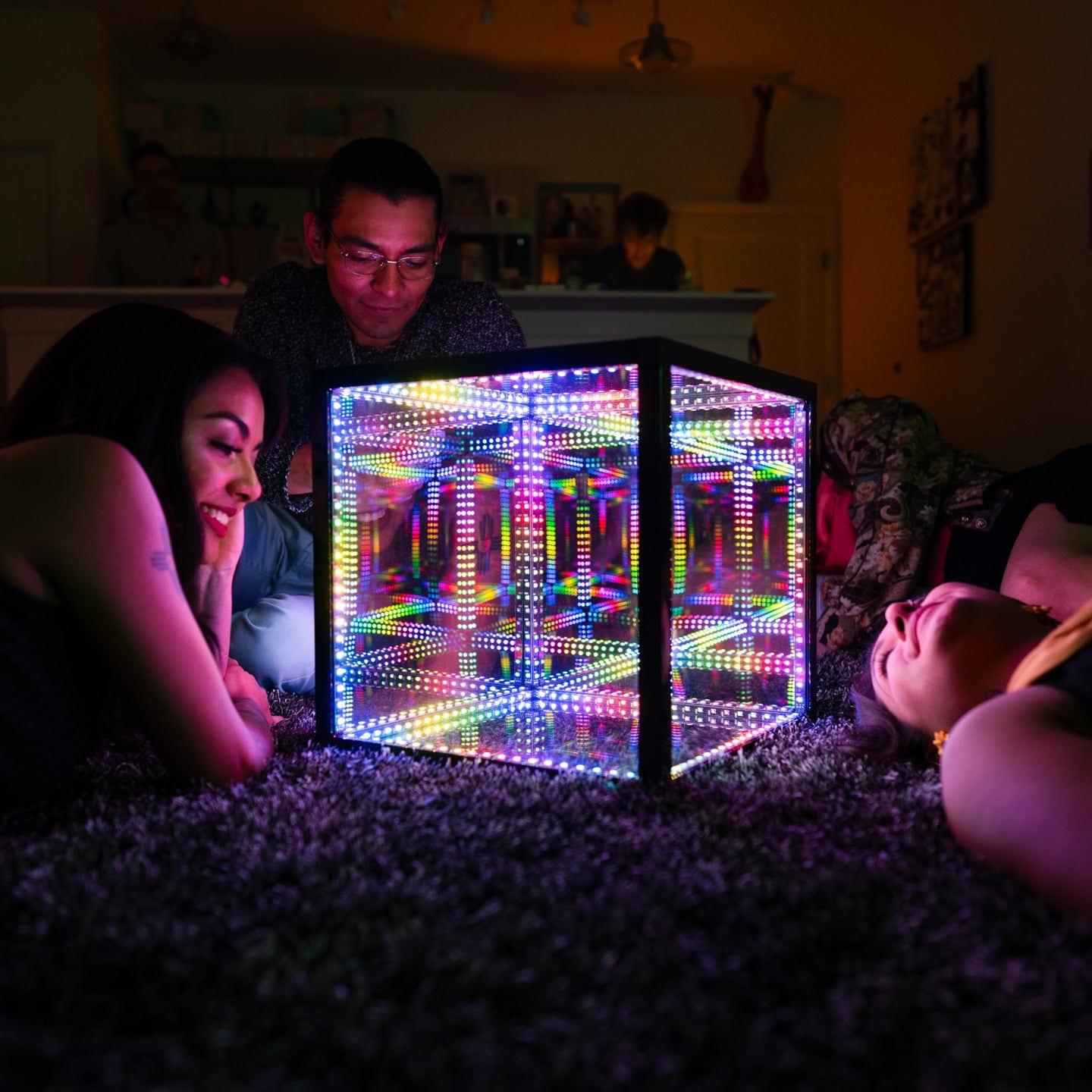 Group of friends gathered around a Hypercube wondering what are infinite lights