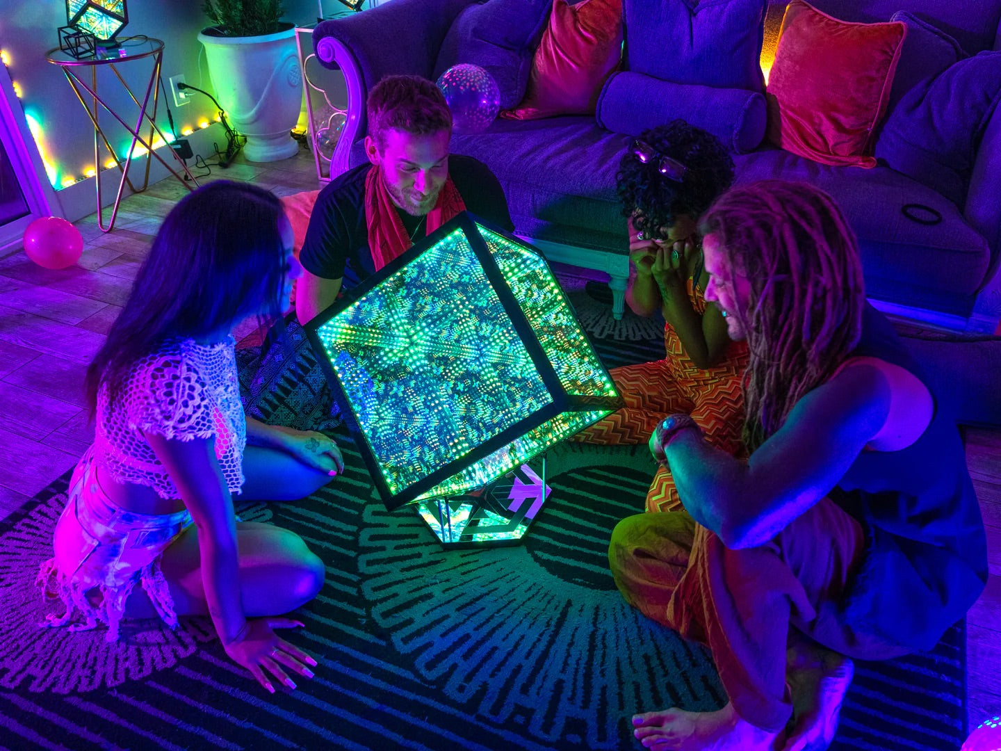 Four persons at a house party sitting down, gathered around a HyperCube, chilling due to decorative lighting ideas