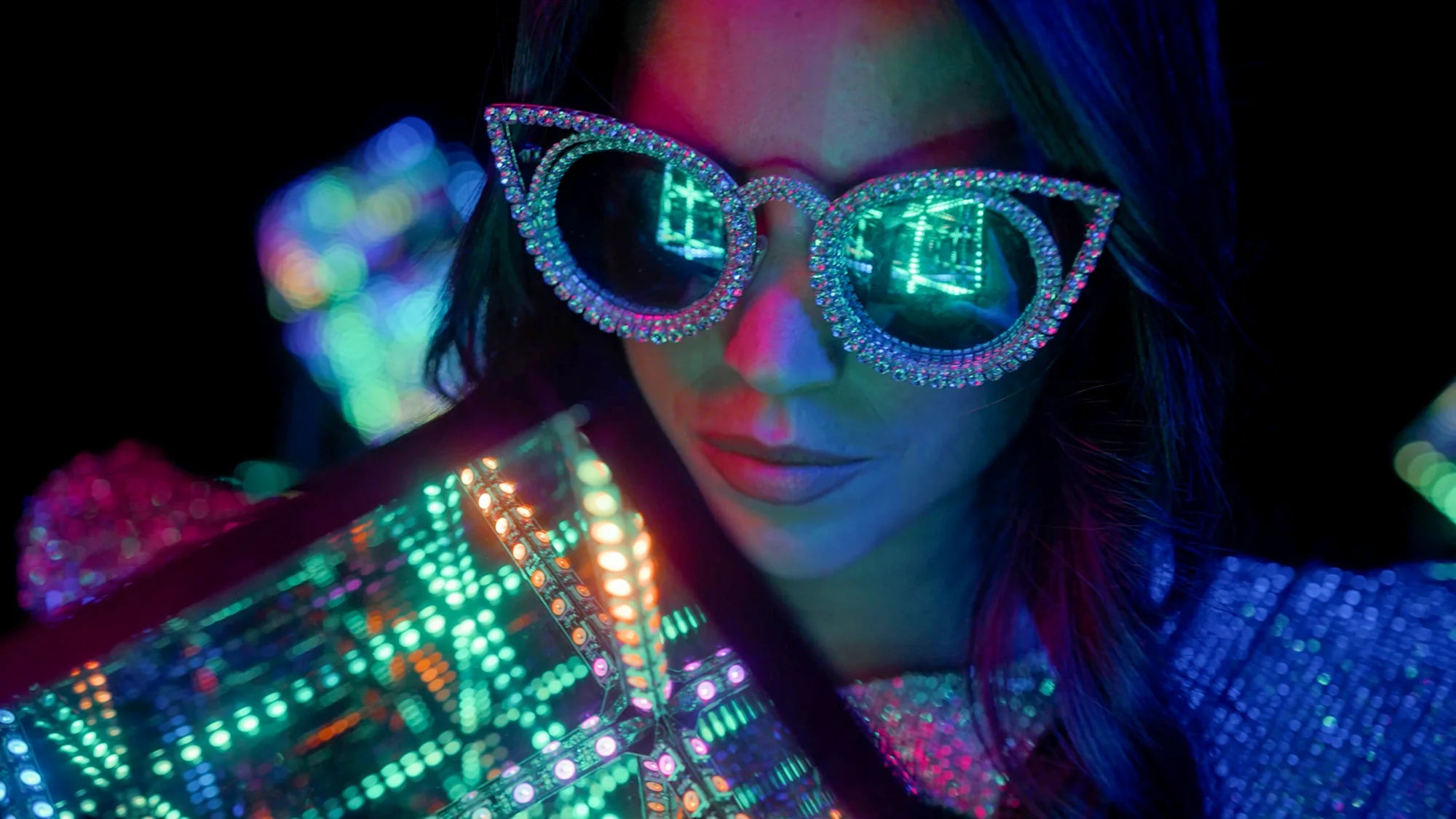 woman with sunglasses up close to led light cube